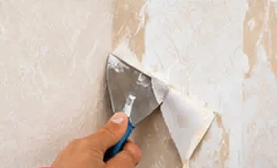 Old wallpaper being removed with a scraper